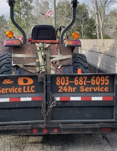 A&D tree service lettered trailer hauling tractor cayce