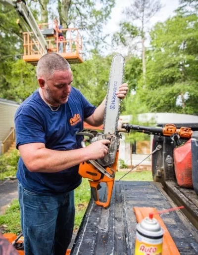 A&D worker tuning husqvarna chainsaw tailgate cayce