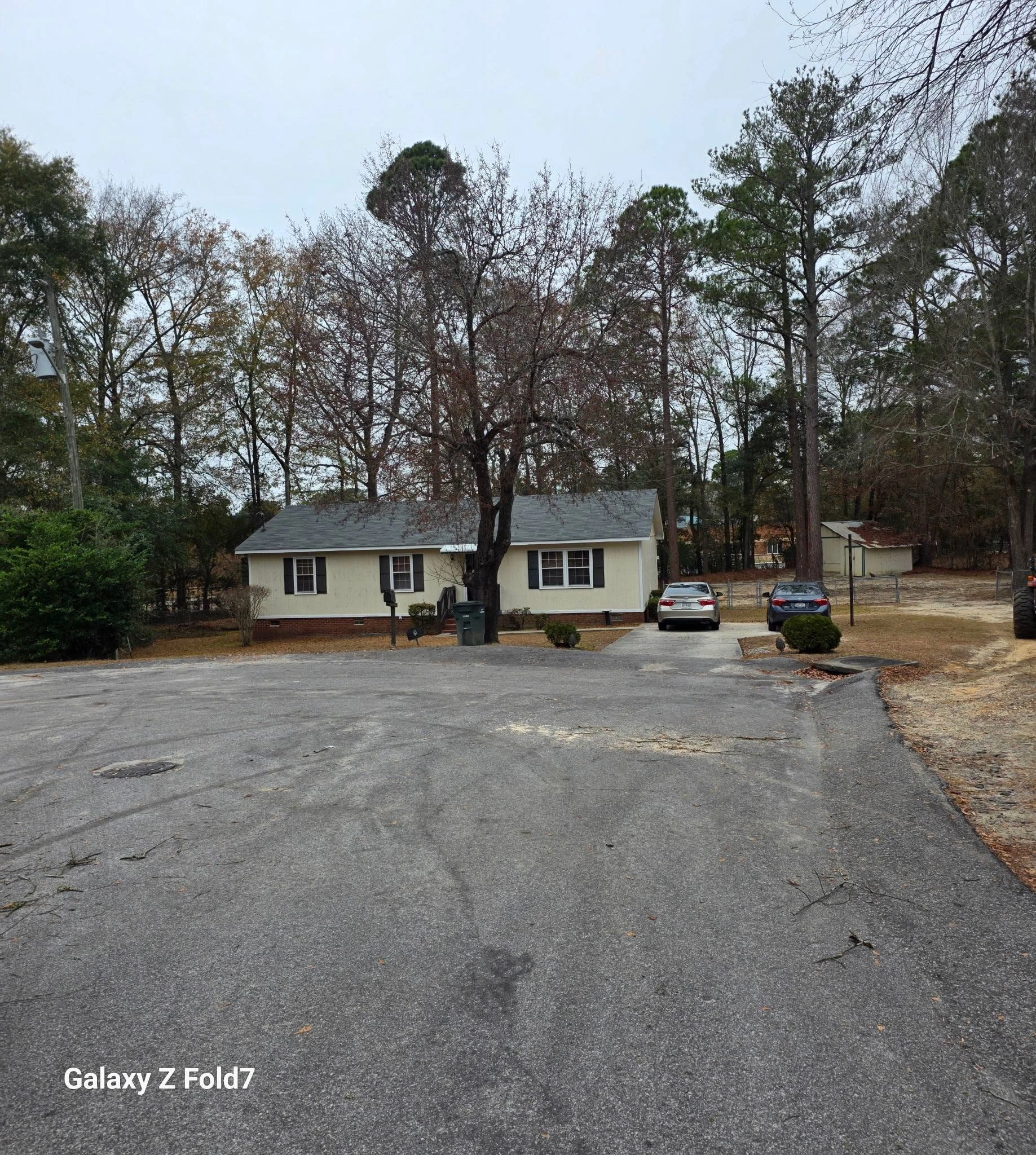 Bare oak front yard yellow ranch house cul de sac two sedans