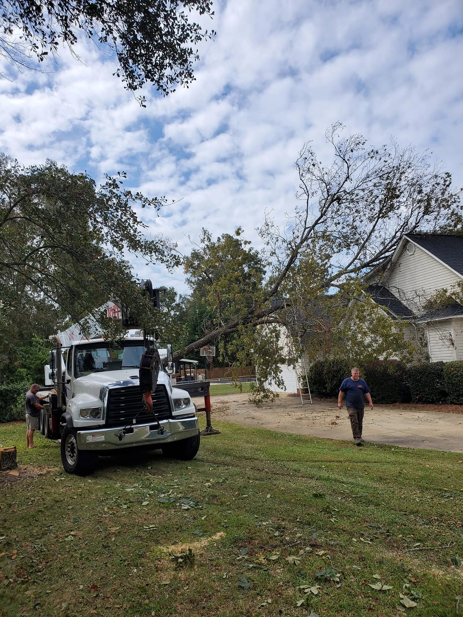 Boom crane truck fallen tree white house roof cayce
