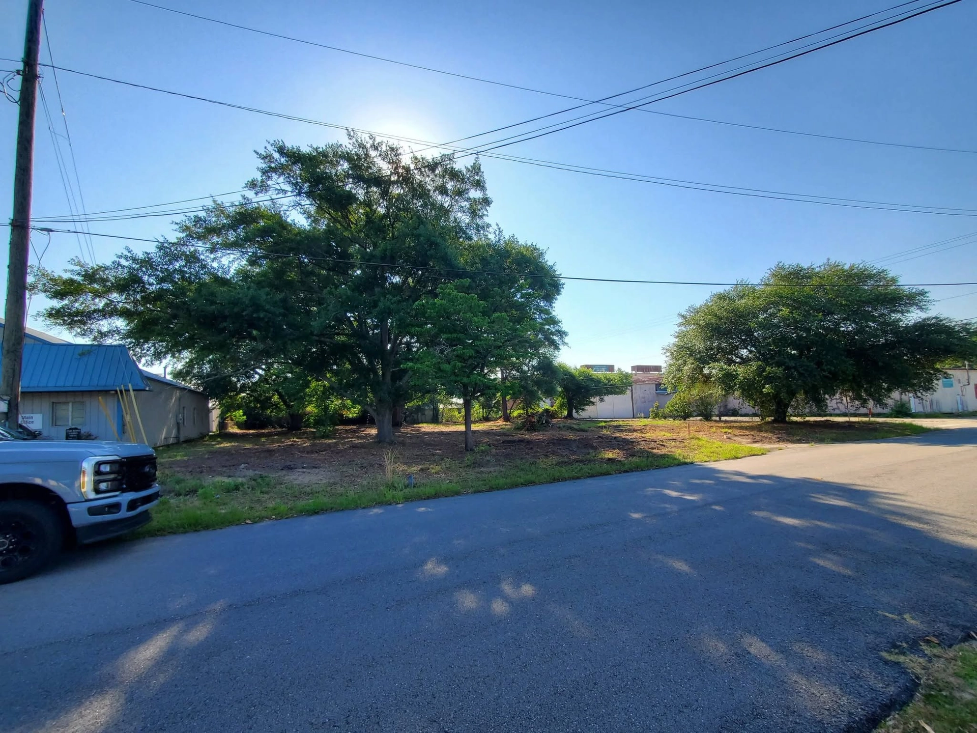 Cleared underbrush live oaks corner lot blue metal roof cayc