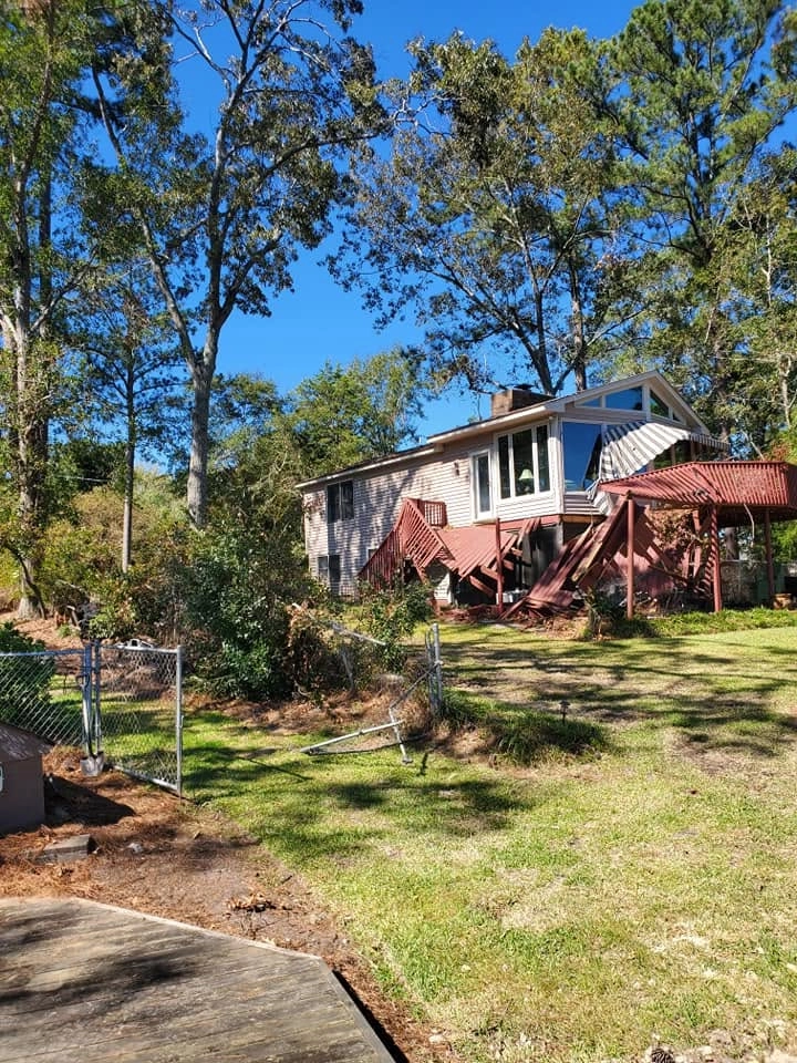 Collapsed red deck storm damage lakefront vinyl house bent c