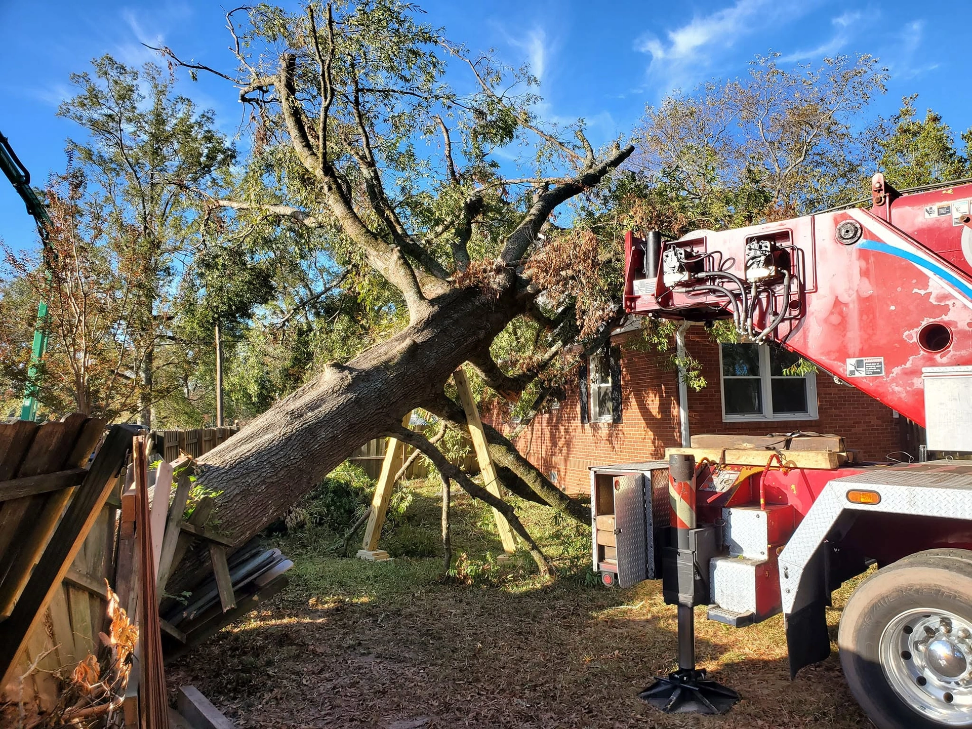 Fallen oak wood brace posts red crane truck brick house cayc
