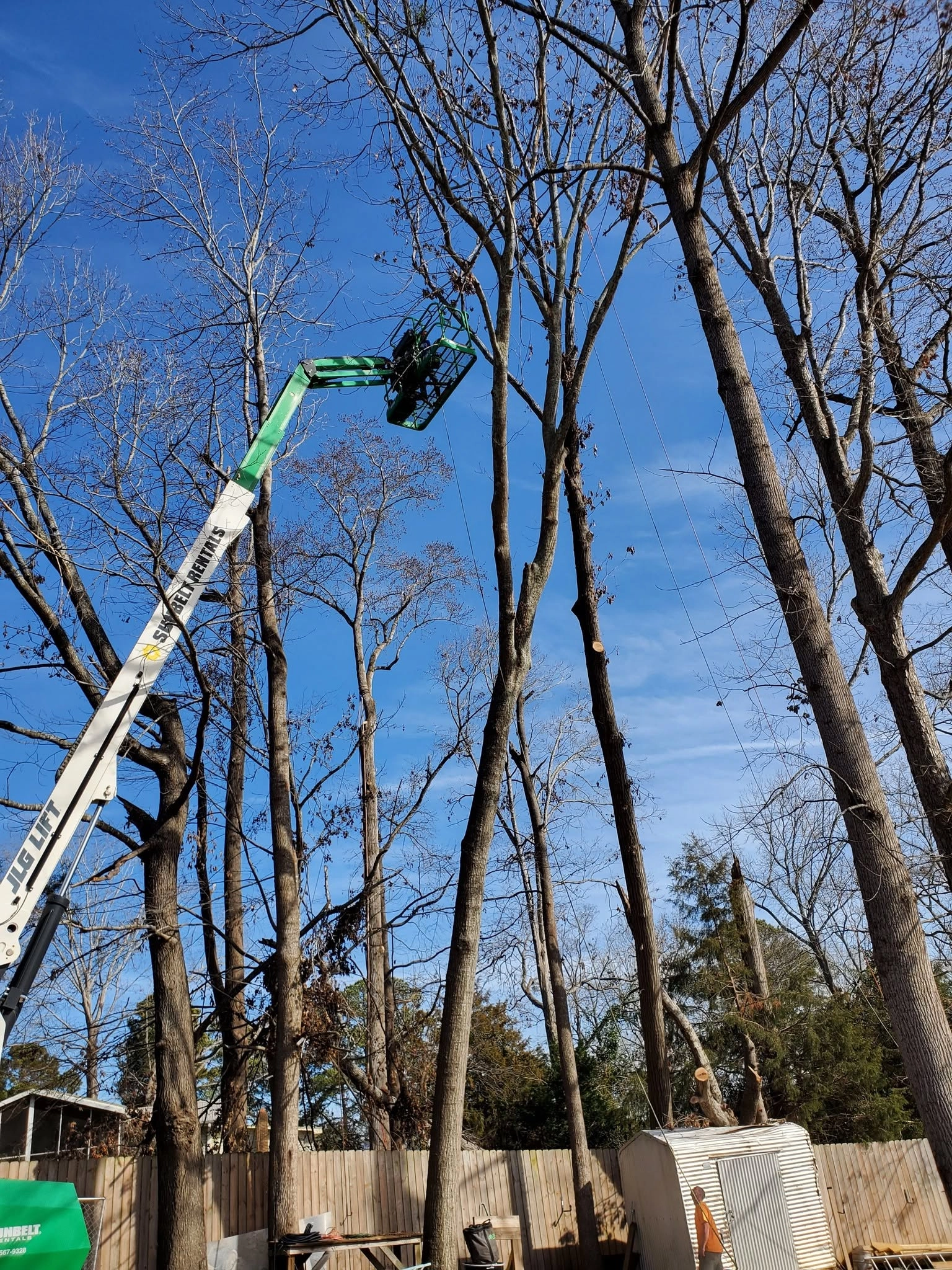Jlg boom lift topped hardwood metal shed privacy fence cayce
