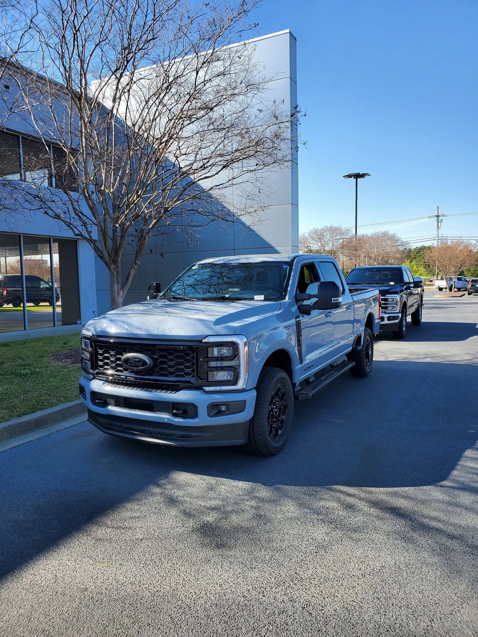 Light blue ford super duty pickup dealership lot bare crape 