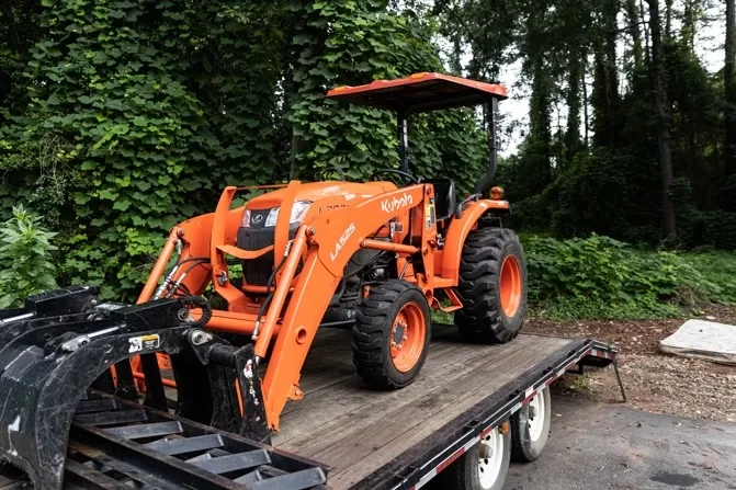 Orange kubota la525 loader tractor flatbed trailer west colu