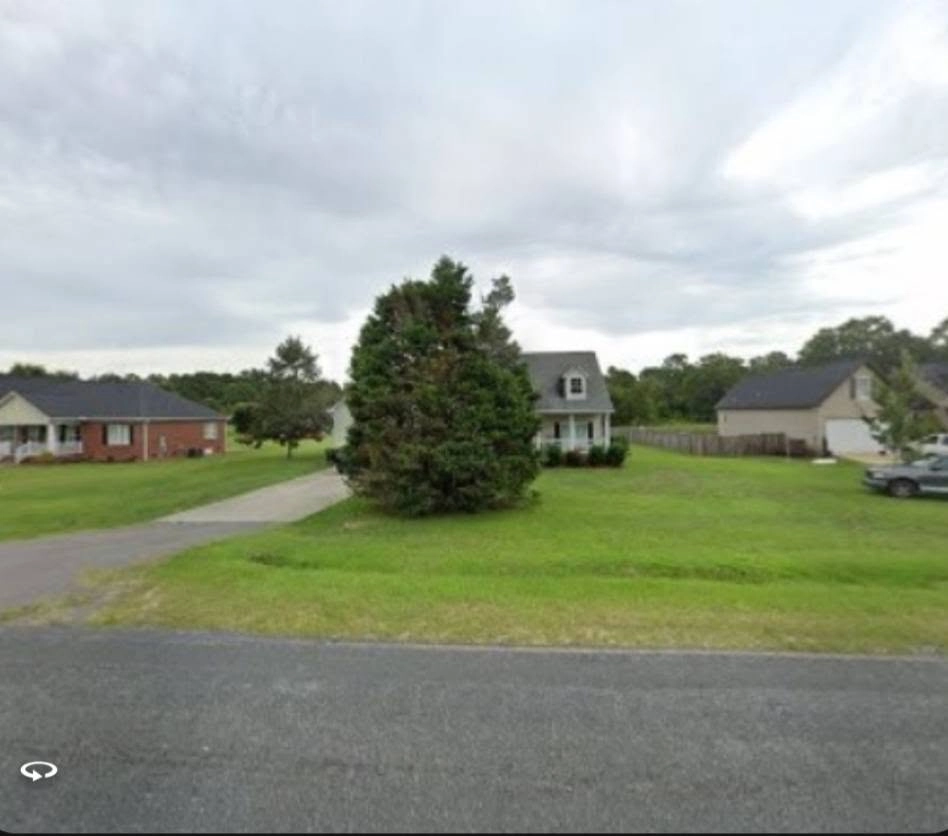 Overgrown leyland cypress front yard cape cod house street v