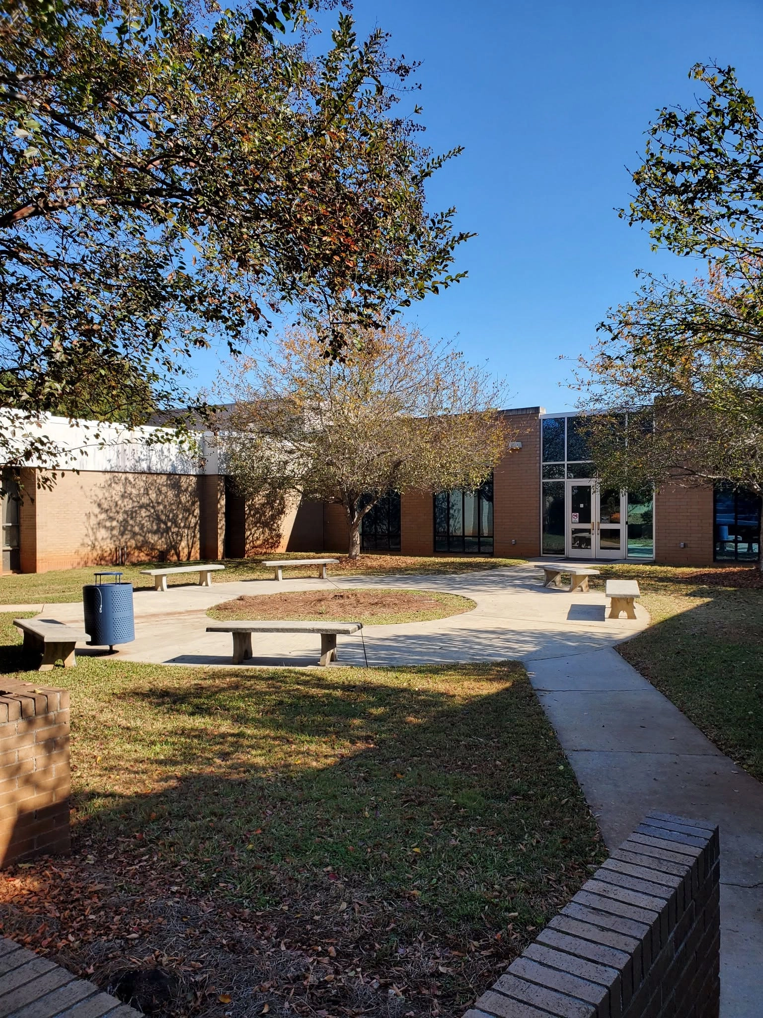School courtyard crape myrtle concrete benches blue trash ca