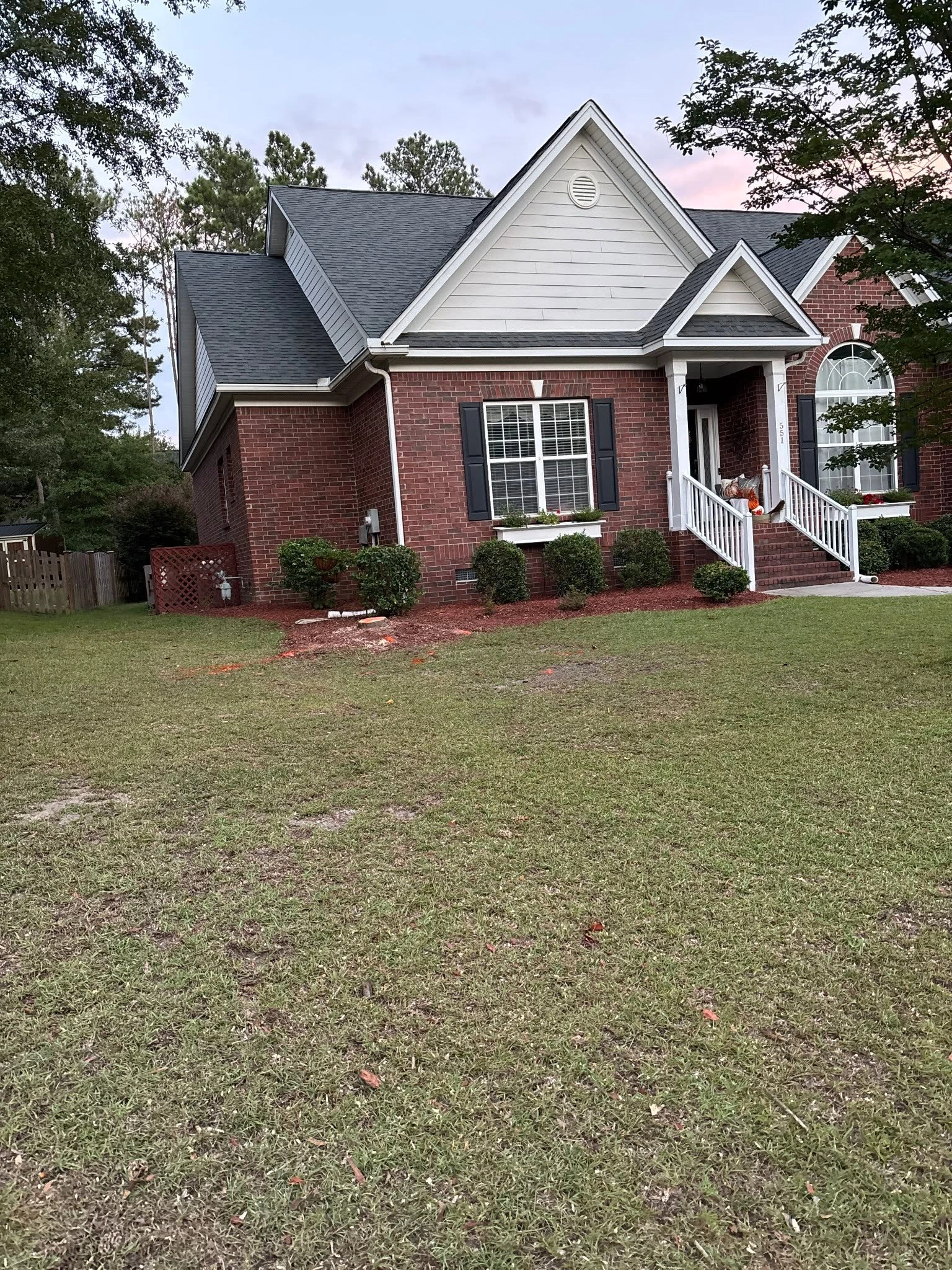 Stump sawdust red mulch brick house black shutters cayce