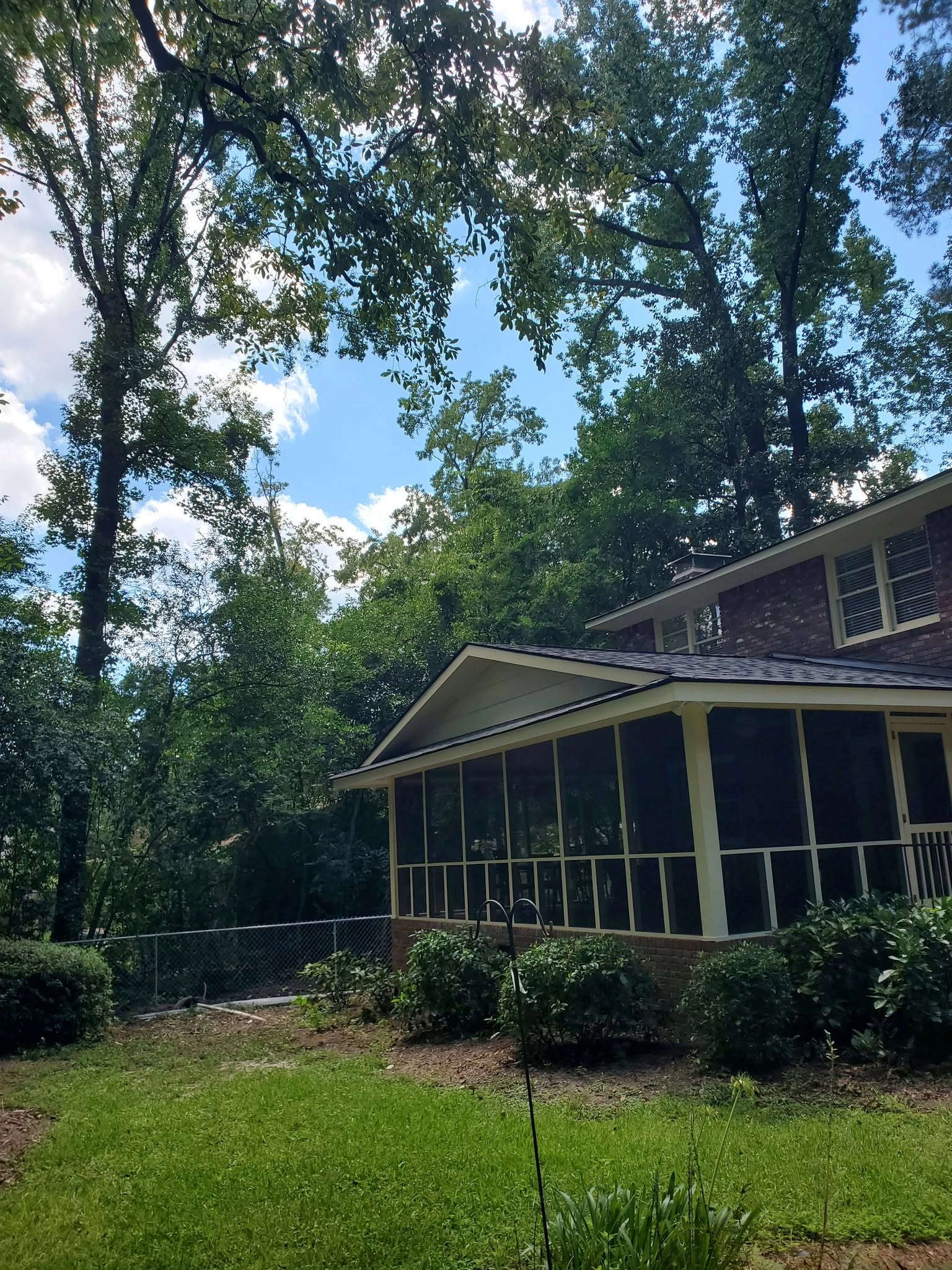 Tall hardwood canopy over screened porch brick two story bac