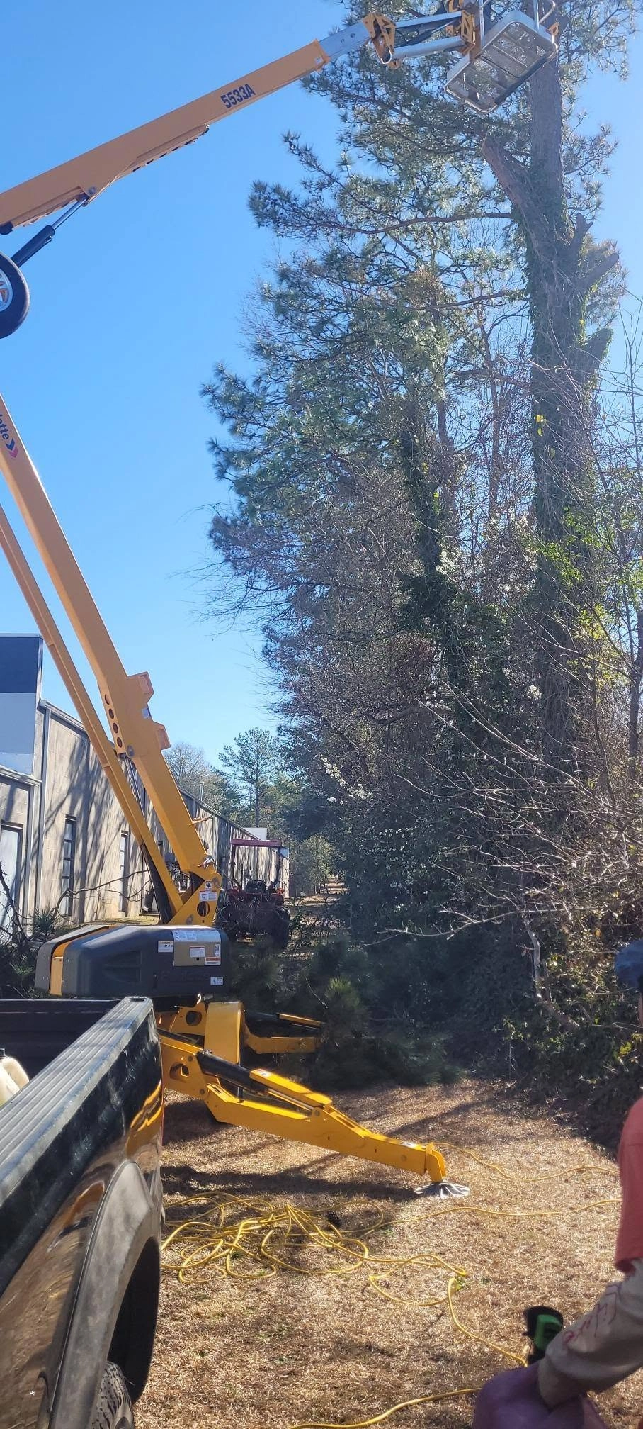 Towable boom lift extended tall pine metal sided building sp