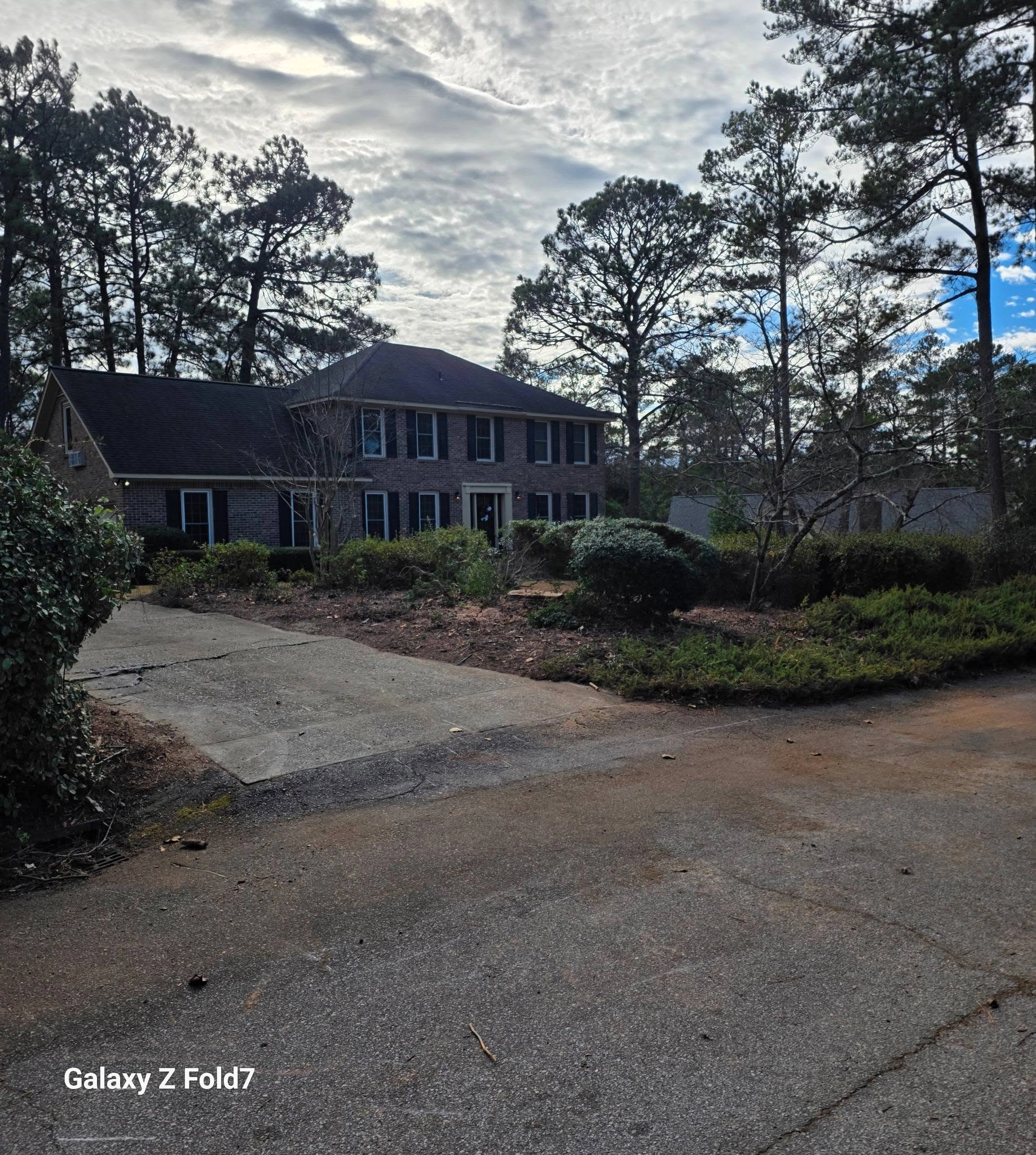 Two story brick colonial pine needle bed asphalt driveway ca