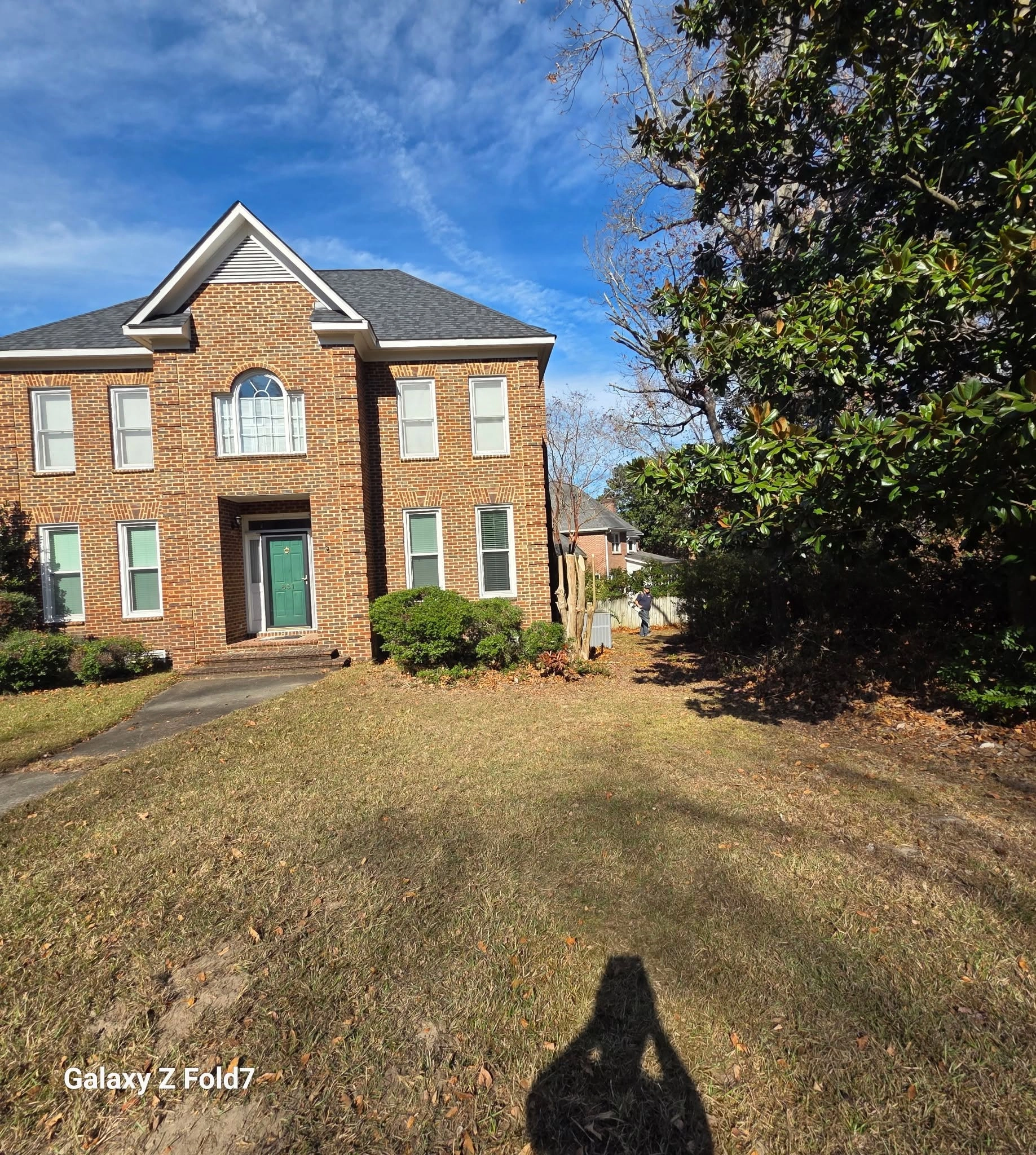 Two story brick house green door magnolia front lawn cayce s