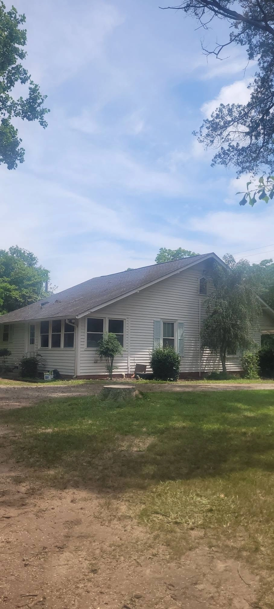 White siding house blue shutters front yard stump cayce